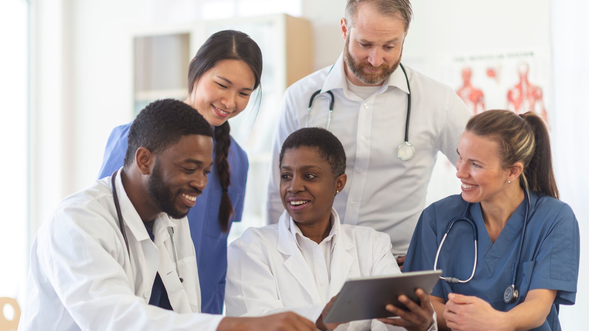 Doctors and nurses meeting together and looking over a tablet