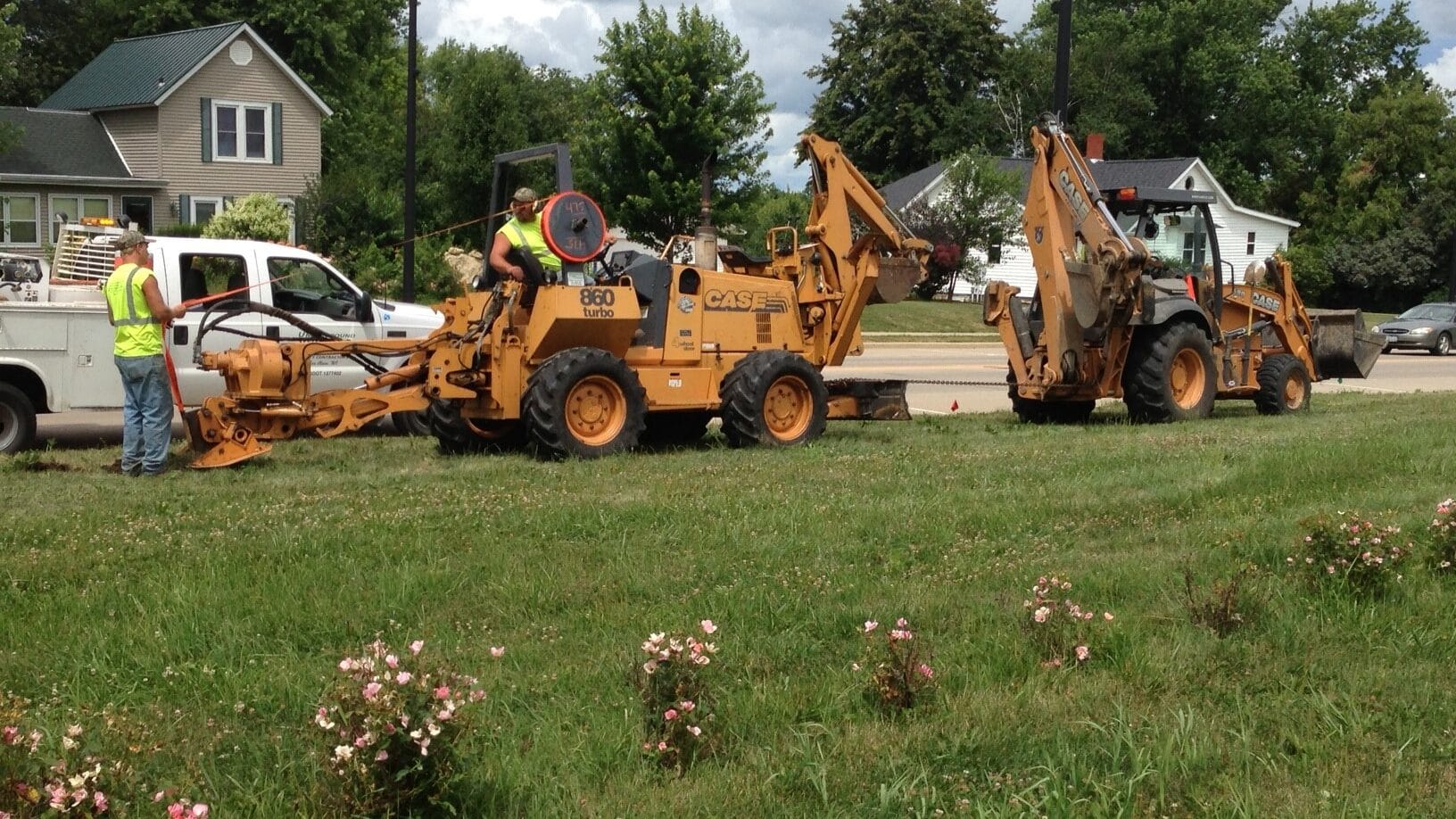 Backhoe equipment laying fiber into the ground
