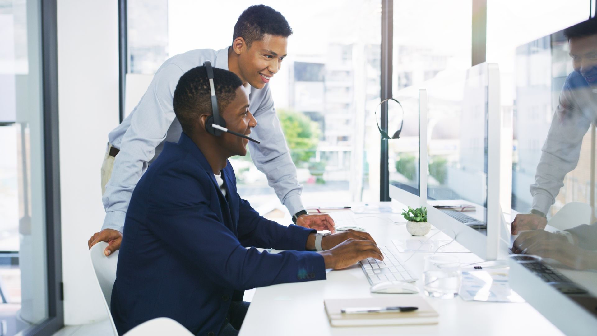 A help desk employee working with another team member