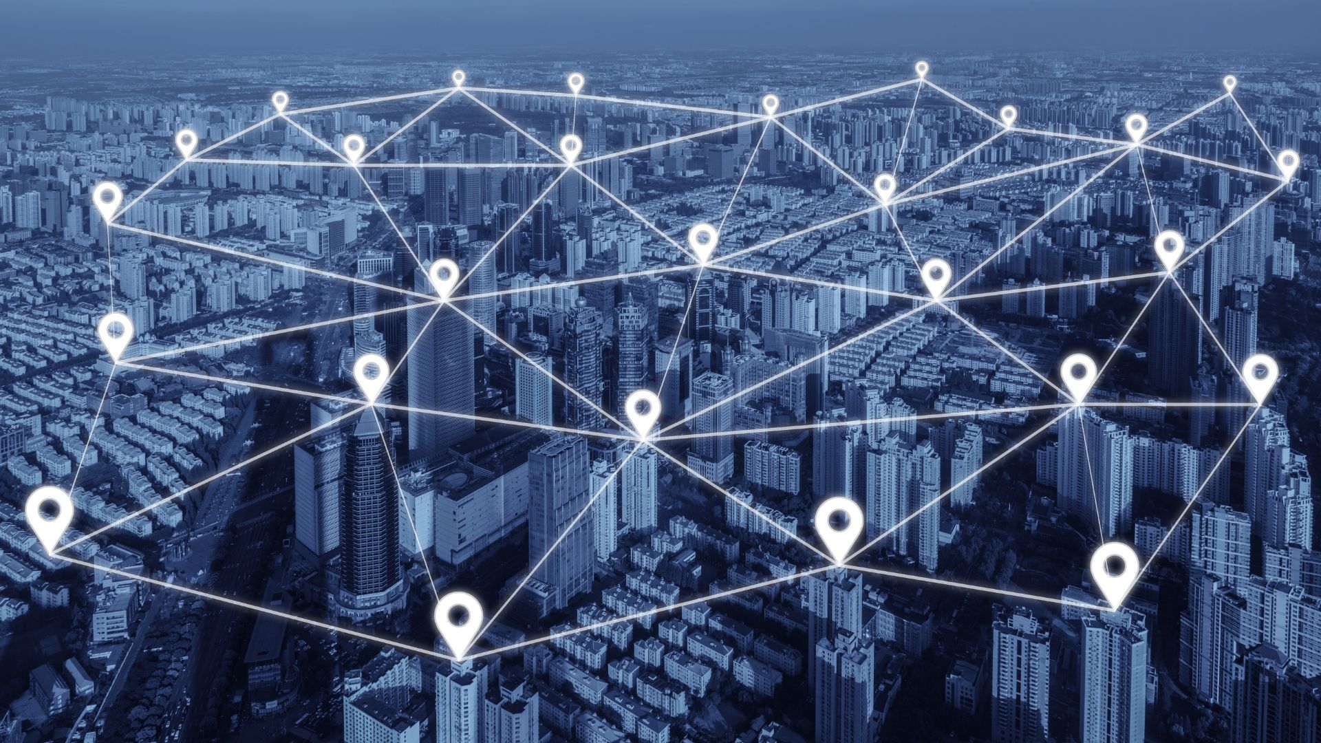Several buildings in a large city are all connected by pin points.