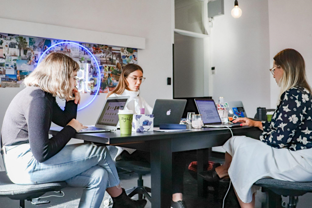 Three women working on their laptops.
